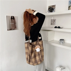Detail of checkered tote bag with large capacity and cute fish plush pendant accessory