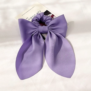 Detailansicht eines lila Satin-Haargummis mit großer Schleife im eleganten französischen Stil