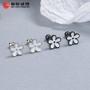 Detailed macro view of white daisy stud earrings in silver and black metal frames