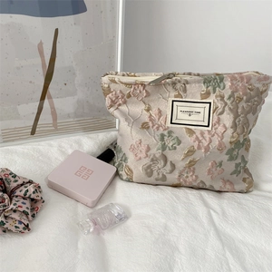 Vue macro du tissu jacquard à fleurs en relief 3D et de la fermeture éclair du grand sac à cosmétiques