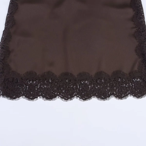 Close-up of dark brown satin fabric with intricate lace trim detail on the hem