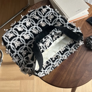 Detail der 3D-Blumenstickerei auf schwarzer Canvas-Tasche mit Magnetverschluss und Label
