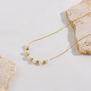 Elegant gold stainless steel necklace with natural white pearls and gold beads on stone