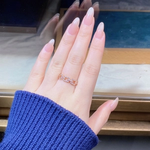 Detailed close-up of rose gold S925 silver link ring with pave diamonds on finger
