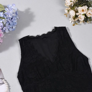 Détail d'un caraco noir en dentelle à col en V avec mesh floral délicat et texture élégante