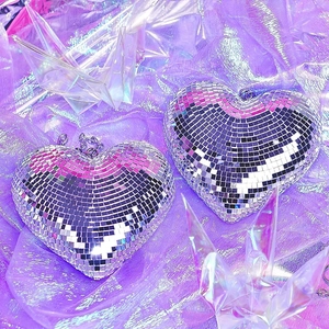 Silver mirror heart-shaped disco ball ornament on purple fabric for party decor