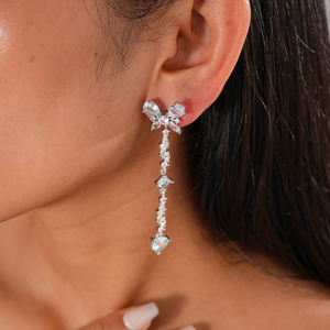 Close-up of silver long tassel earrings with light blue crystals on female model