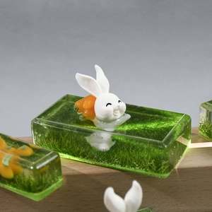 Detail of creative resin rabbit landscape with carrot inside transparent green cube