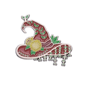 Wizard hat enamel brooch with sunflower and vine design on a clean white background