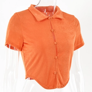 Close-up of orange velvet polo top showing soft texture and button-front cropped design