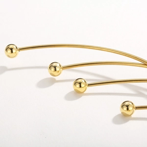 Detailed macro view of golden metal neck collar featuring curved rods and spherical accents