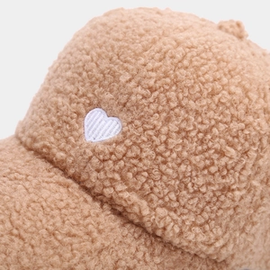Close-up of white heart embroidery on brown sherpa fleece winter baseball cap