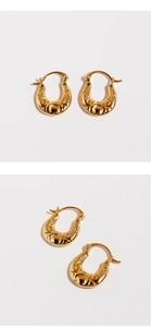 Detailed macro view of gold U-shaped earrings with vintage embossed hollow patterns
