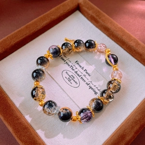 Macro view of beaded crystal bracelet with gold accents in a luxury jewelry box