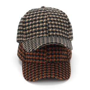 Detail of plaid baseball caps in yellow and orange wool fabric for autumn and winter