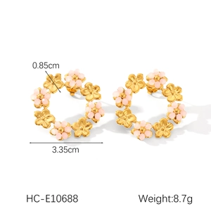 Détail des créoles fleurs dorées avec perles roses montrant le diamètre de 3,35 cm de large