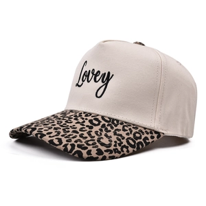 Detail of embroidered Lovey script on beige canvas cap with leopard print brim