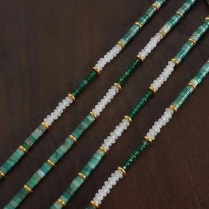 Detail of bohemian handmade necklace with green jade beads and golden spacers