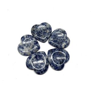 Macro view of five polished heart-shaped blue sodalite thumb worry stones on white background