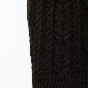 Women's black high neck knitted sweater vest featuring classic cable knit and ribbed hem details
