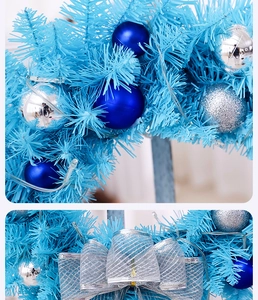Macro detail of blue Christmas wreath with silver ornaments and LED string lights