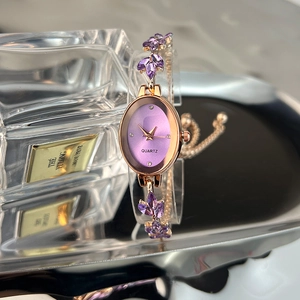 Detail of luxury oval quartz watch with purple leaf crystal bracelet and gold rose casing