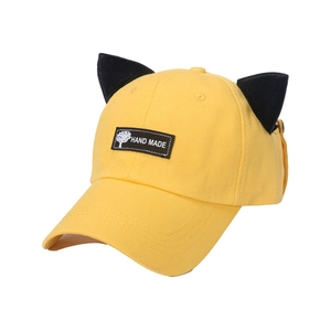 Détail de la casquette jaune avec oreilles de chat noires et étiquette textile Hand Made