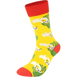 Détail de chaussettes en maille jaune avec motifs cactus verts, chat blanc et touches rouges
