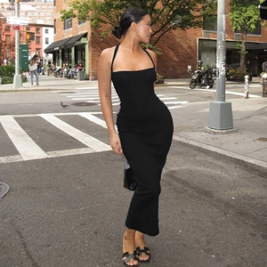 Close-up of black halter neck backless dress in slim-fit knit fabric on urban street