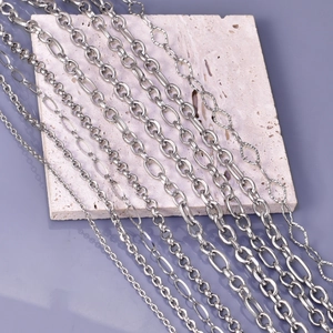 Various styles of silver stainless steel Cuban and link chains laid on marble surface