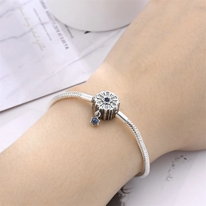 Detail of silver tree of life charm bracelet with blue star pendant on female wrist