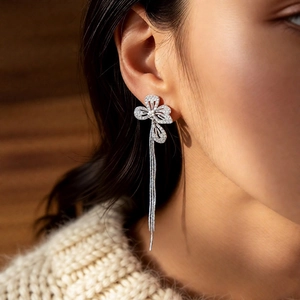 Macro shot of silver tassel earrings with flower design and sparkling zircon stones