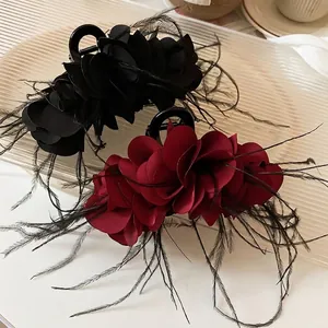 Elegant tiered fabric flower hair claw clip with delicate feathers in black and wine red