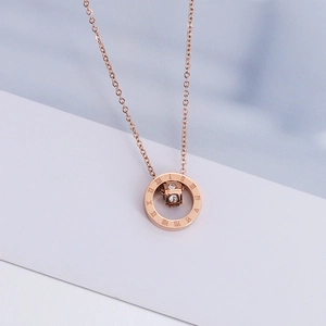 Macro shot of rose gold necklace with Roman numeral double rings and crystal inlays