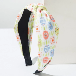 Detail showing Easter egg and bunny patterns on a white fabric knotted headband