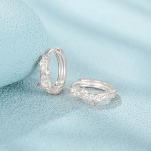 Macro detail of silver star hoop earrings with sparkling clear cubic zirconia stones