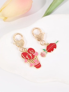 Detail of heart hot air balloon and red lips charms on a white ceramic tray