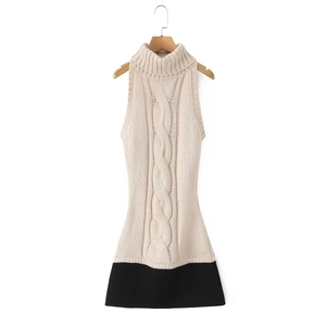 Close-up of beige knit sleeveless dress featuring a cable-knit pattern and black contrast hem
