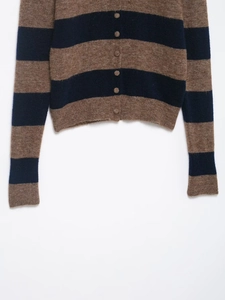 Detailed texture of a brown and navy striped knit cardigan with small matching buttons