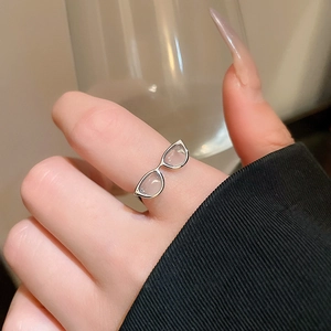 Macro shot of silver y2k sunglasses ring with translucent lenses worn on finger