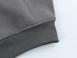 Macro detail of dark grey ribbed knit cuffs and hem showing high quality stitching