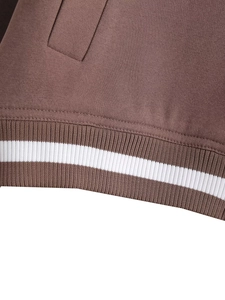 Dettaglio macro del tessuto a maglia marrone caffè con bordo a coste a righe bianche e cuciture