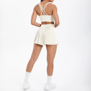 Détail du soutien-gorge de sport dos croisé et mini-jupe plissée en blanc cassé