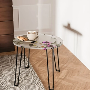 Modern side table with floral patterns and black hairpin legs in a home setting