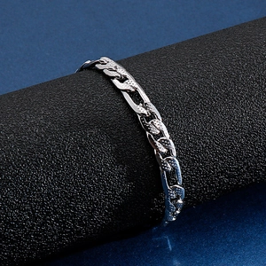 Macro shot of silver stainless steel Figaro chain bracelet with embossed link texture