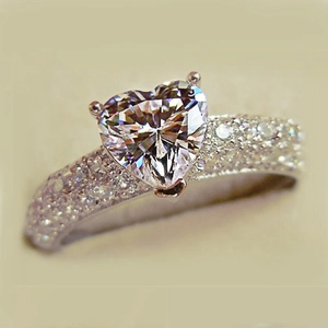 Macro shot of a heart-shaped diamond ring with a sparkling pavé diamond-set band