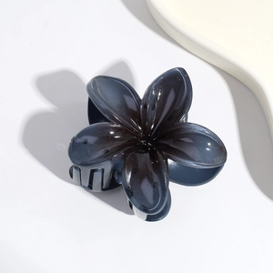 Detail view of a dark grey Y2K flower hair claw with a glossy gradient finish