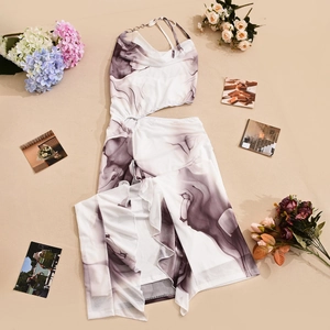 Flat lay of white off-shoulder dress with ink print and cutout waist detail