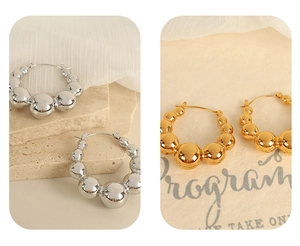 Close-up of minimalist bubble hoop earrings in polished gold and silver metallic finishes