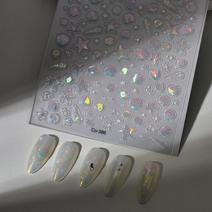 Makro-Detail von 5D-holografischen Meeresmuschel-Nagelstickern mit 3D-Seesternmustern